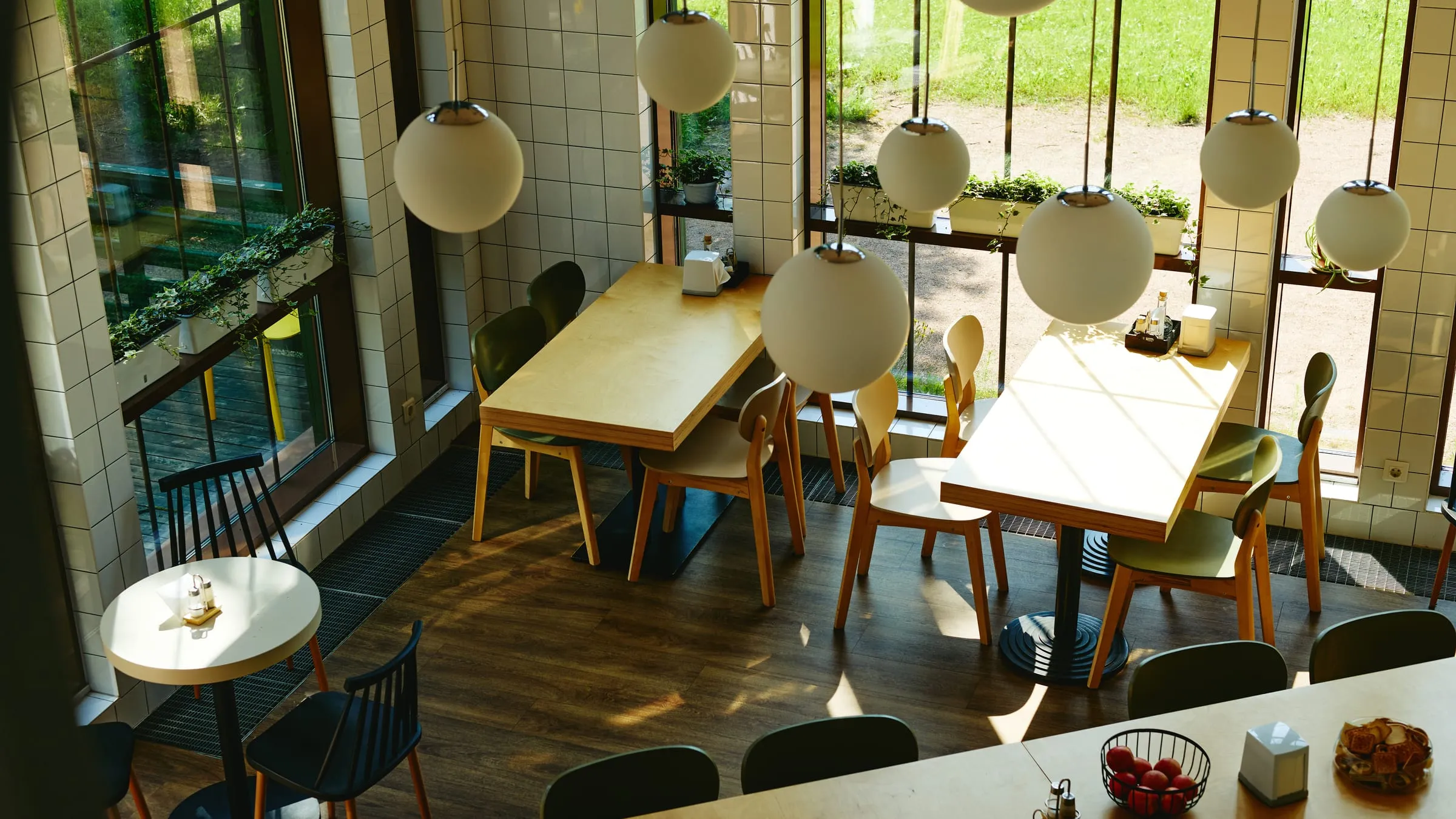 An empty café interior with sunlight streaming across wooden tables — ungraded.