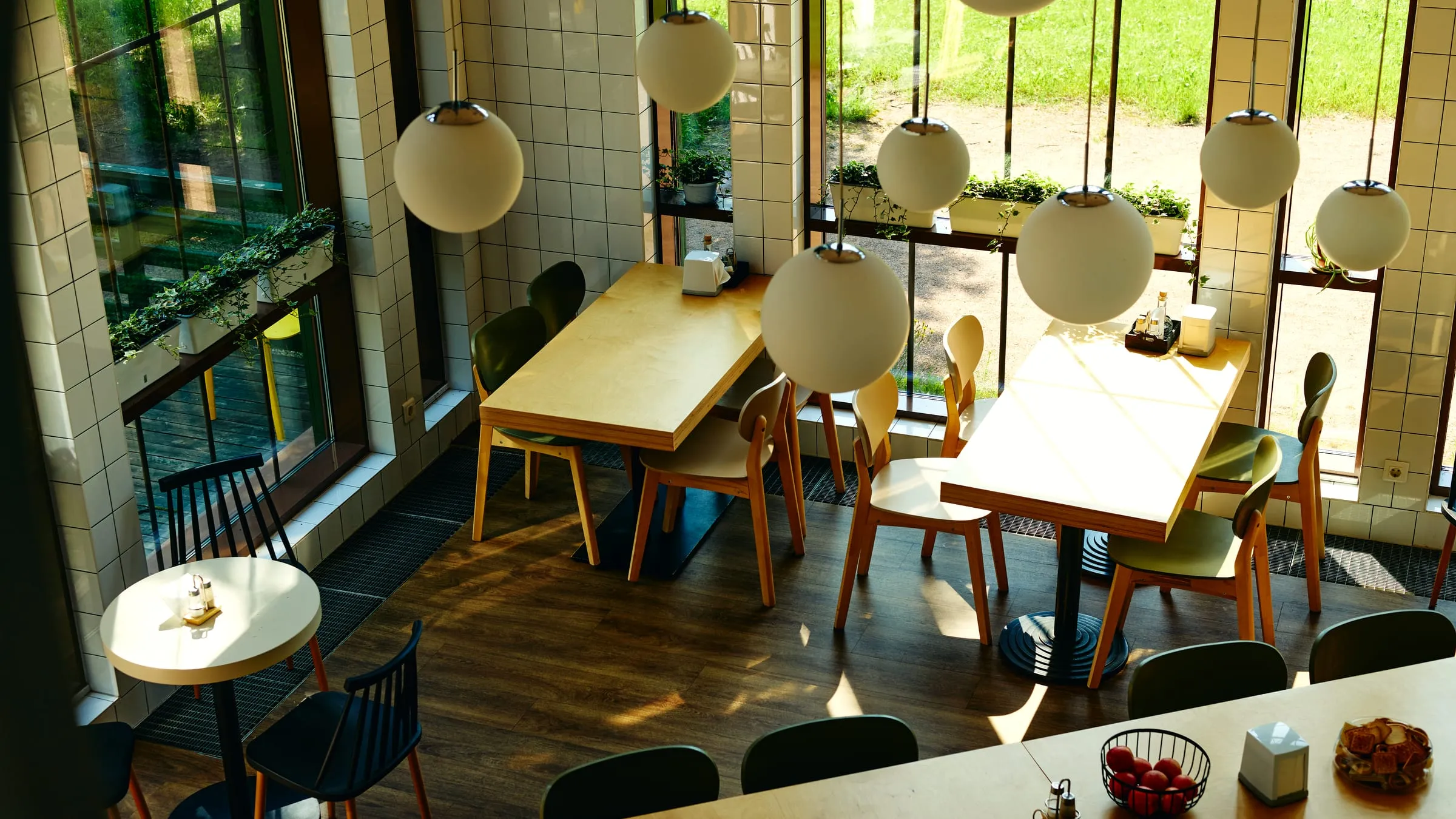 An empty café interior with sunlight streaming across wooden tables — graded.